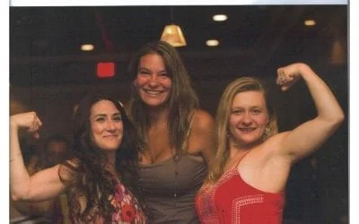 Three smiling women flexing biceps, celebrating. TITLE