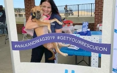 Smiling woman holds a puppy at a