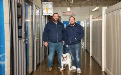 Two men and a bulldog stand in a