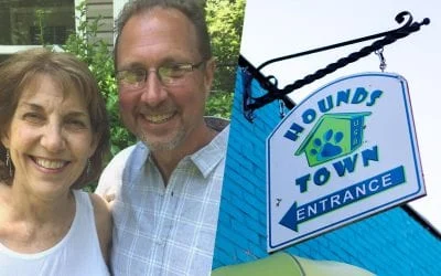 Smiling couple next to a Hounds Town dog daycare