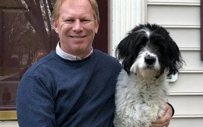 Rich Stoll smiling, holding his black and