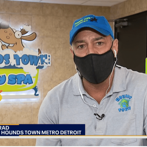 Brad from Hounds Town Metro Detroit wears a mask and Hounds Town shirt in front