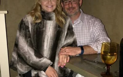 Smiling woman in faux fur and man in glasses,