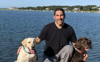 Bob LeBlanc smiling with a yellow lab