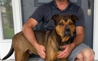 Man in a grey shirt holding a large brown and