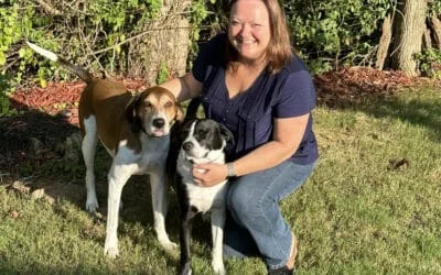 Smiling woman Mary Hoy crouches with